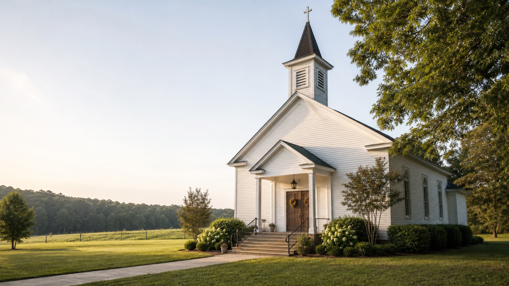 A representative rural church building surrounded by trees and morning light